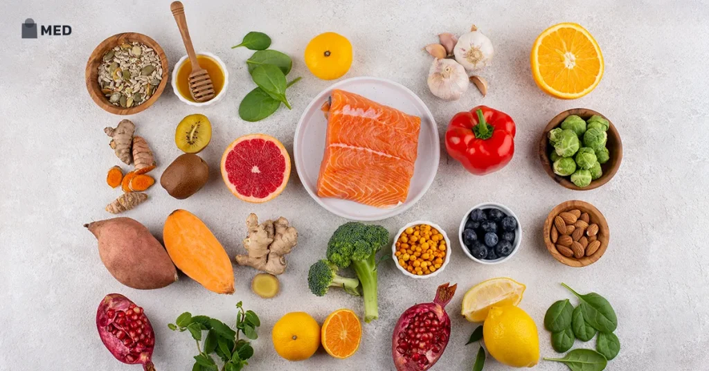 Assorted nutrient-rich foods including salmon, fruits, vegetables, nuts, seeds, and citrus arranged on a light background